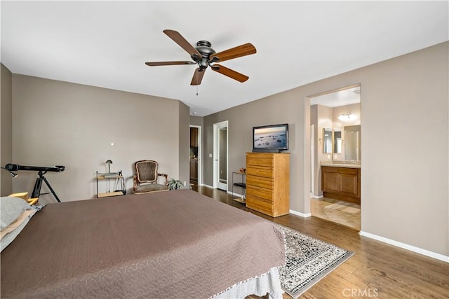 unfurnished bedroom with ensuite bathroom, ceiling fan, wood finished floors, and baseboards