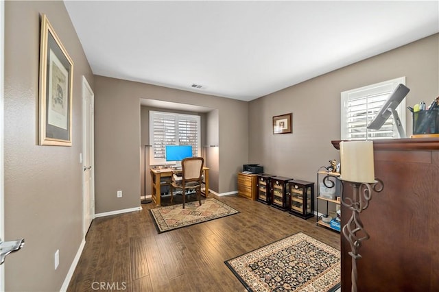 office space featuring wood finished floors, visible vents, and baseboards