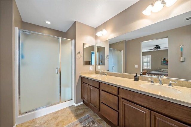 bathroom featuring a stall shower, tile patterned flooring, a sink, and ensuite bath