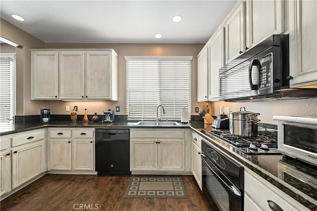 kitchen featuring black appliances, dark wood-style flooring, a sink, and recessed lighting