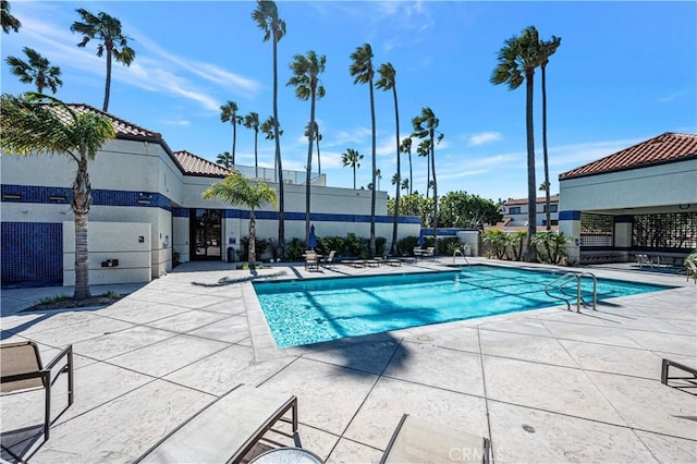 pool with a patio area and fence