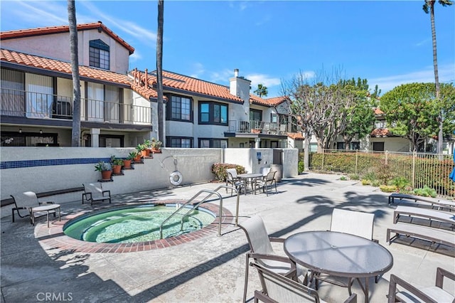 view of patio featuring fence and a community hot tub