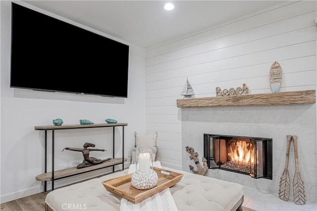 interior space featuring recessed lighting, a fireplace, wood finished floors, and baseboards