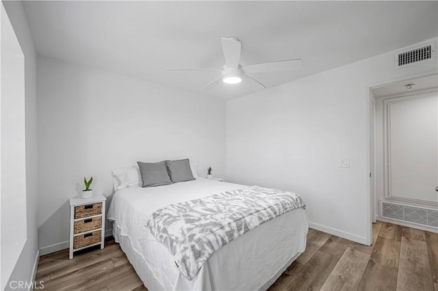 bedroom featuring wood finished floors, visible vents, and baseboards