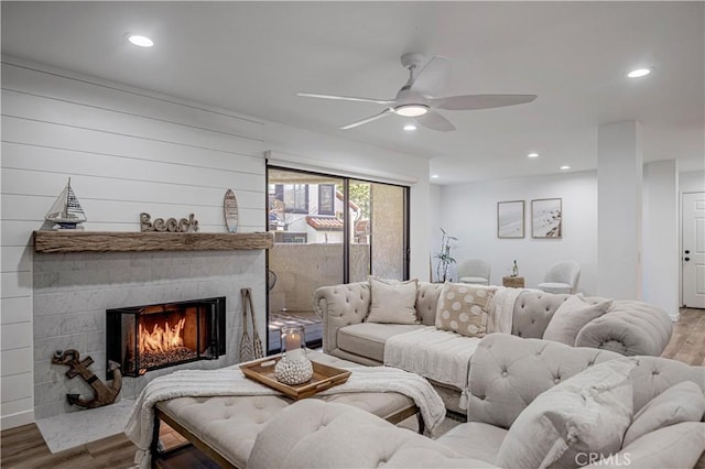 living room with a ceiling fan, recessed lighting, a large fireplace, and wood finished floors