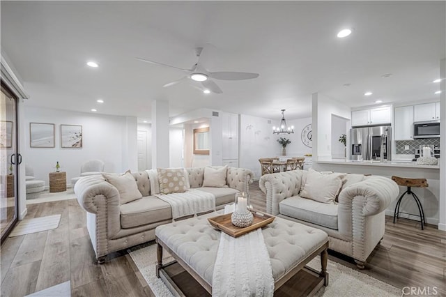 living room with ceiling fan with notable chandelier, recessed lighting, and wood finished floors