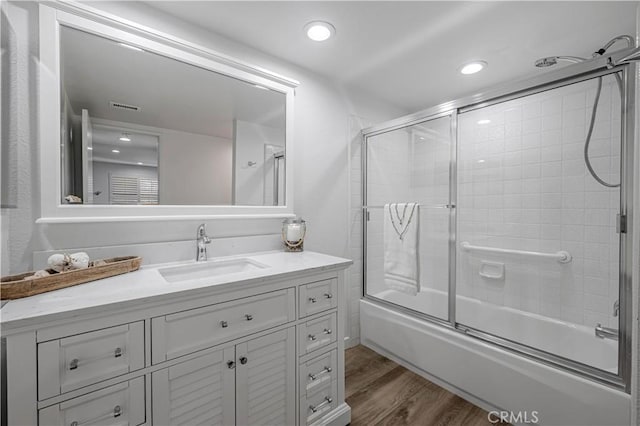 full bathroom featuring visible vents, enclosed tub / shower combo, wood finished floors, vanity, and recessed lighting