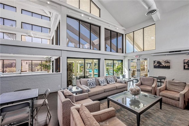 living area featuring vaulted ceiling, a textured wall, french doors, and visible vents