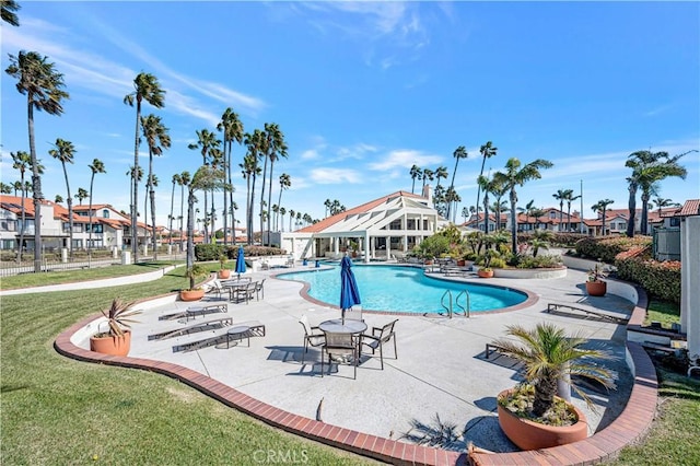 pool featuring a lawn and a patio area