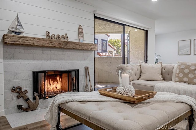 interior space with a warm lit fireplace and wood finished floors