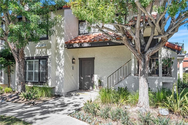 view of front of house featuring a tiled roof and stucco siding