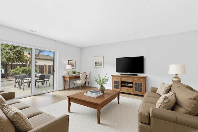 living area featuring light wood-type flooring and baseboards