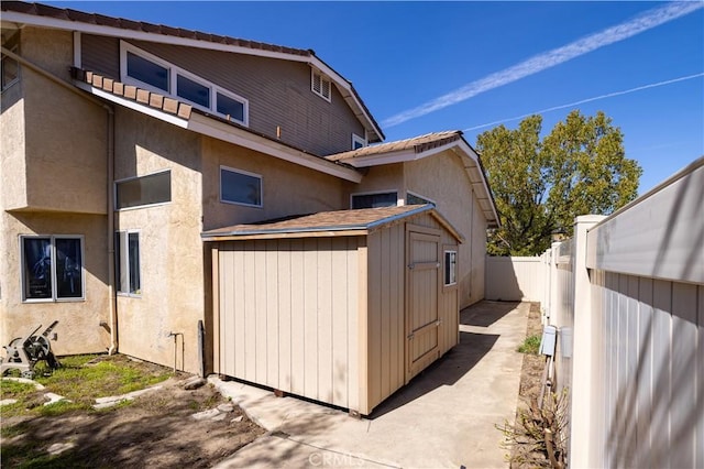 view of side of home featuring an outdoor structure and a fenced backyard