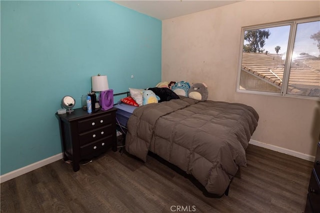 bedroom with baseboards and wood finished floors