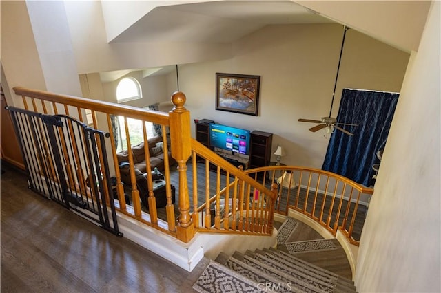 staircase featuring high vaulted ceiling, wood finished floors, and a ceiling fan