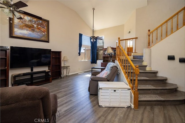 living room featuring wood finished floors, a ceiling fan, baseboards, visible vents, and stairs