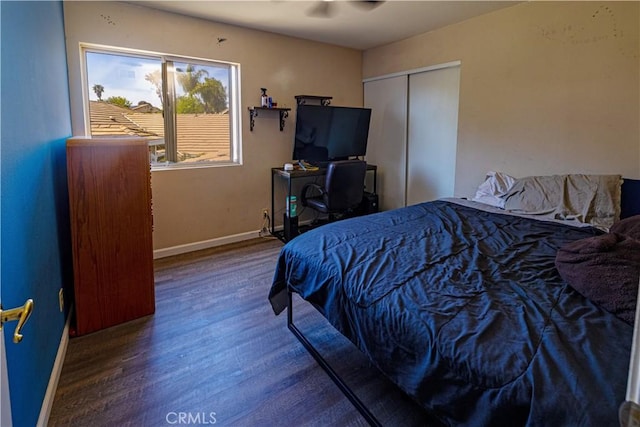 bedroom featuring a closet, baseboards, and wood finished floors