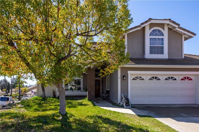 traditional home featuring a garage, concrete driveway, and a front yard