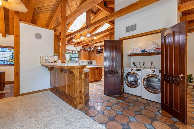 washroom featuring visible vents, a towering ceiling, washer and dryer, laundry area, and baseboards