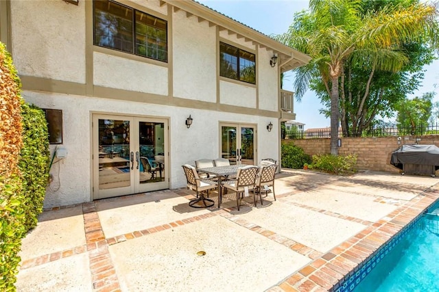 back of house featuring stucco siding, fence, a patio, and french doors