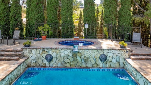 view of swimming pool with an in ground hot tub, a patio, fence, and a fenced in pool