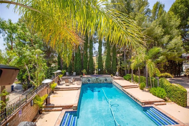 outdoor pool with a patio and fence