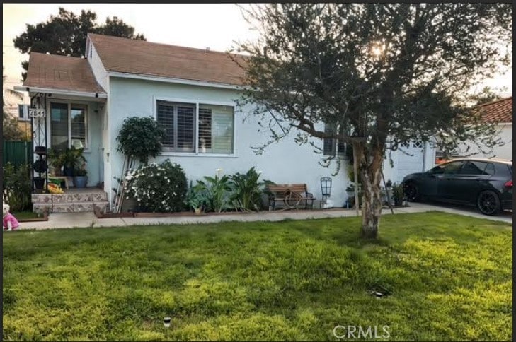 view of front of property with stucco siding and a front lawn