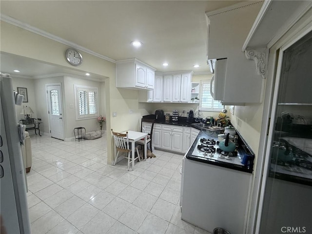 7844 Gainford St, Downey, CA 90240 - kitchen with dark countertops, light tile patterned floors, white cabinets, crown molding, and recessed lighting
