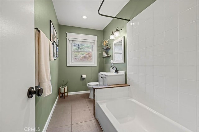 bathroom with a sink, baseboards, toilet, and tile patterned flooring