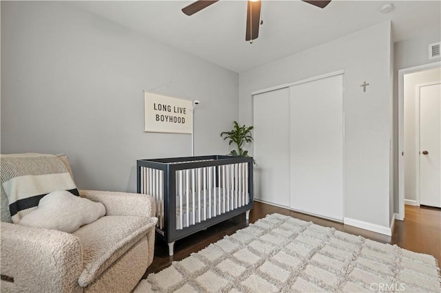 bedroom featuring visible vents, a ceiling fan, wood finished floors, a closet, and baseboards