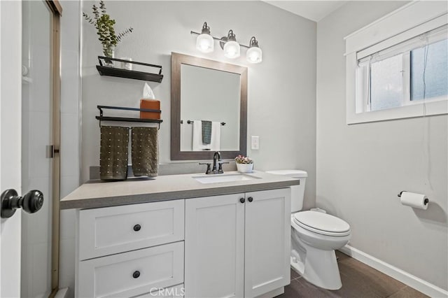 bathroom with baseboards, toilet, and vanity