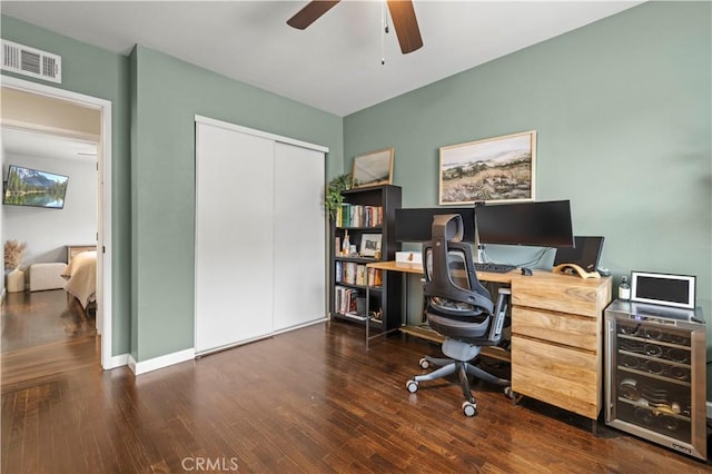 office featuring a ceiling fan, wood finished floors, visible vents, and baseboards