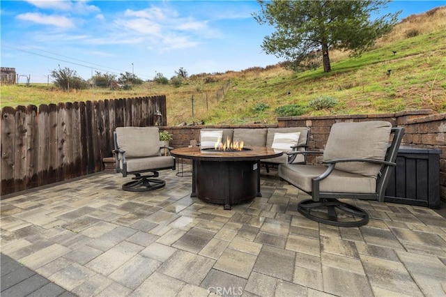 view of patio featuring an outdoor fire pit and fence