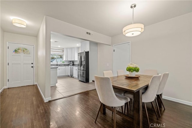 dining room featuring visible vents, baseboards, and wood finished floors