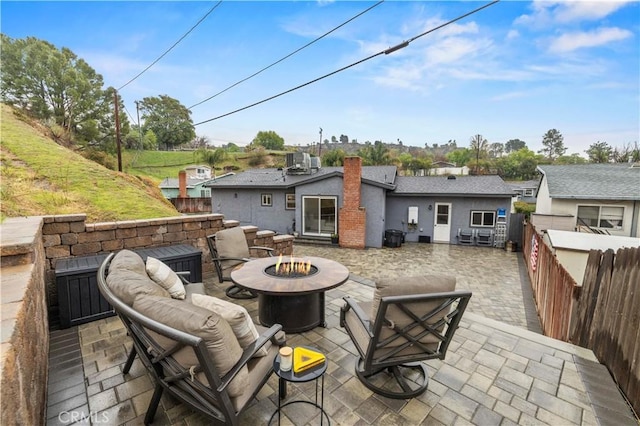 back of property with a patio area, central air condition unit, an outdoor living space with a fire pit, and a fenced backyard