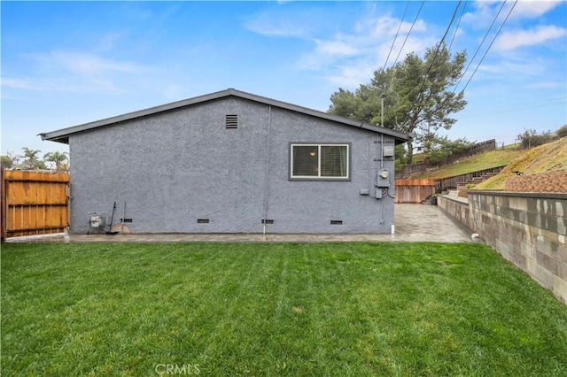 rear view of house with stucco siding, a lawn, a fenced backyard, and crawl space