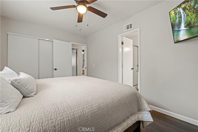 bedroom featuring visible vents, a ceiling fan, wood finished floors, a closet, and baseboards