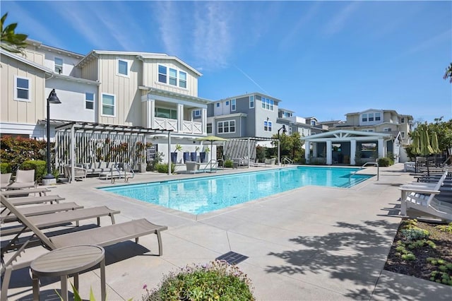 pool with a patio area, a residential view, and a pergola