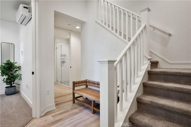 stairs featuring a wall mounted air conditioner, baseboards, wood finished floors, and recessed lighting