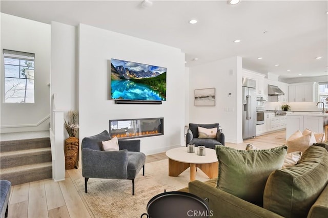 living room featuring a wealth of natural light, recessed lighting, and light wood finished floors