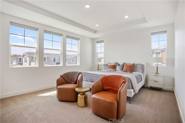 carpeted bedroom with a raised ceiling, recessed lighting, and baseboards