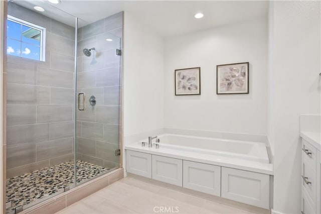 full bathroom with recessed lighting, a stall shower, vanity, and a garden tub