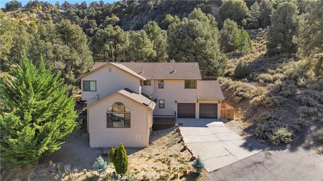 view of front of house with driveway and a forest view