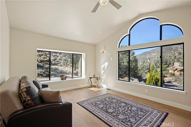 sitting room featuring lofted ceiling, ceiling fan, baseboards, and wood finished floors