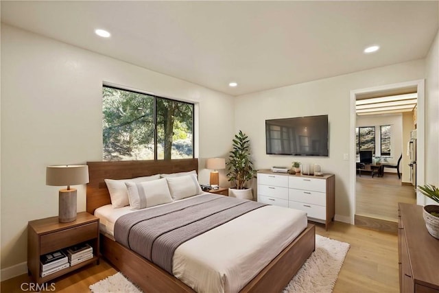 bedroom featuring baseboards, multiple windows, recessed lighting, and light wood-style floors