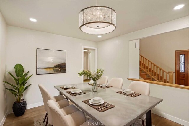 dining space with recessed lighting, dark wood finished floors, stairway, and baseboards