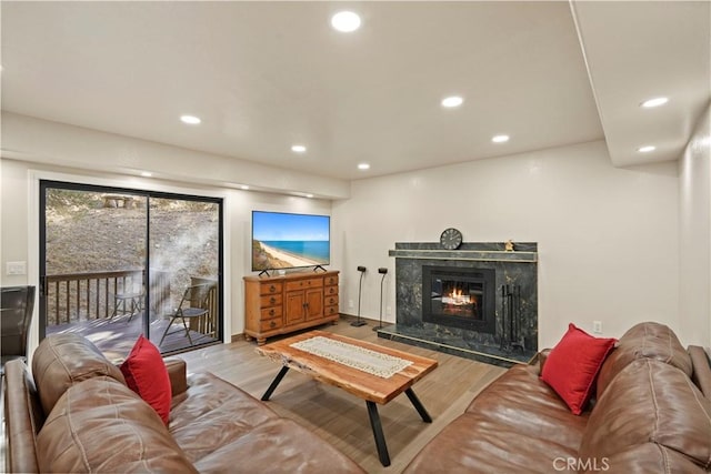 living room with a fireplace, wood finished floors, and recessed lighting