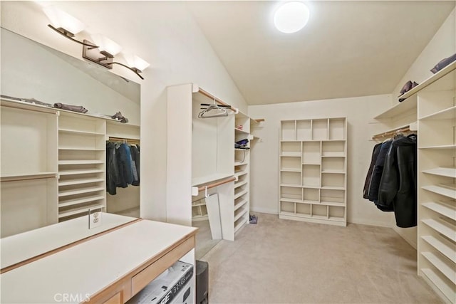 walk in closet featuring light carpet and vaulted ceiling