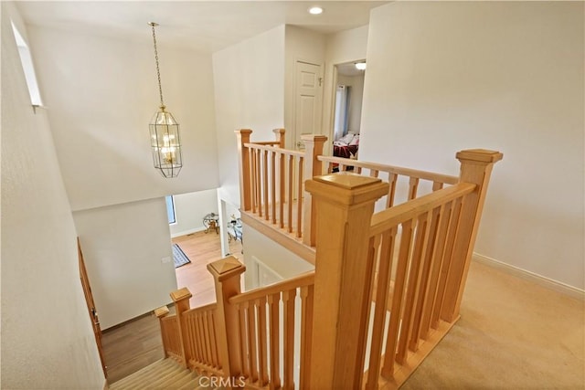 stairway featuring baseboards, wood finished floors, and recessed lighting