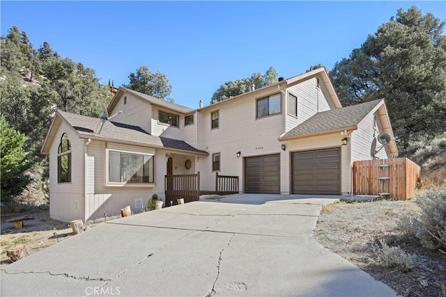 view of front of home with driveway and fence